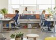 Employees working at height-adjustable benching desks