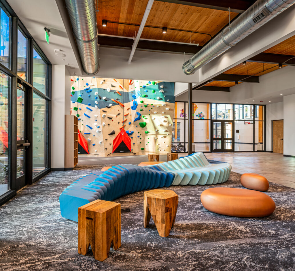 Lounge seating beside the climbing wall at the Idaho Outdoor Fieldhouse