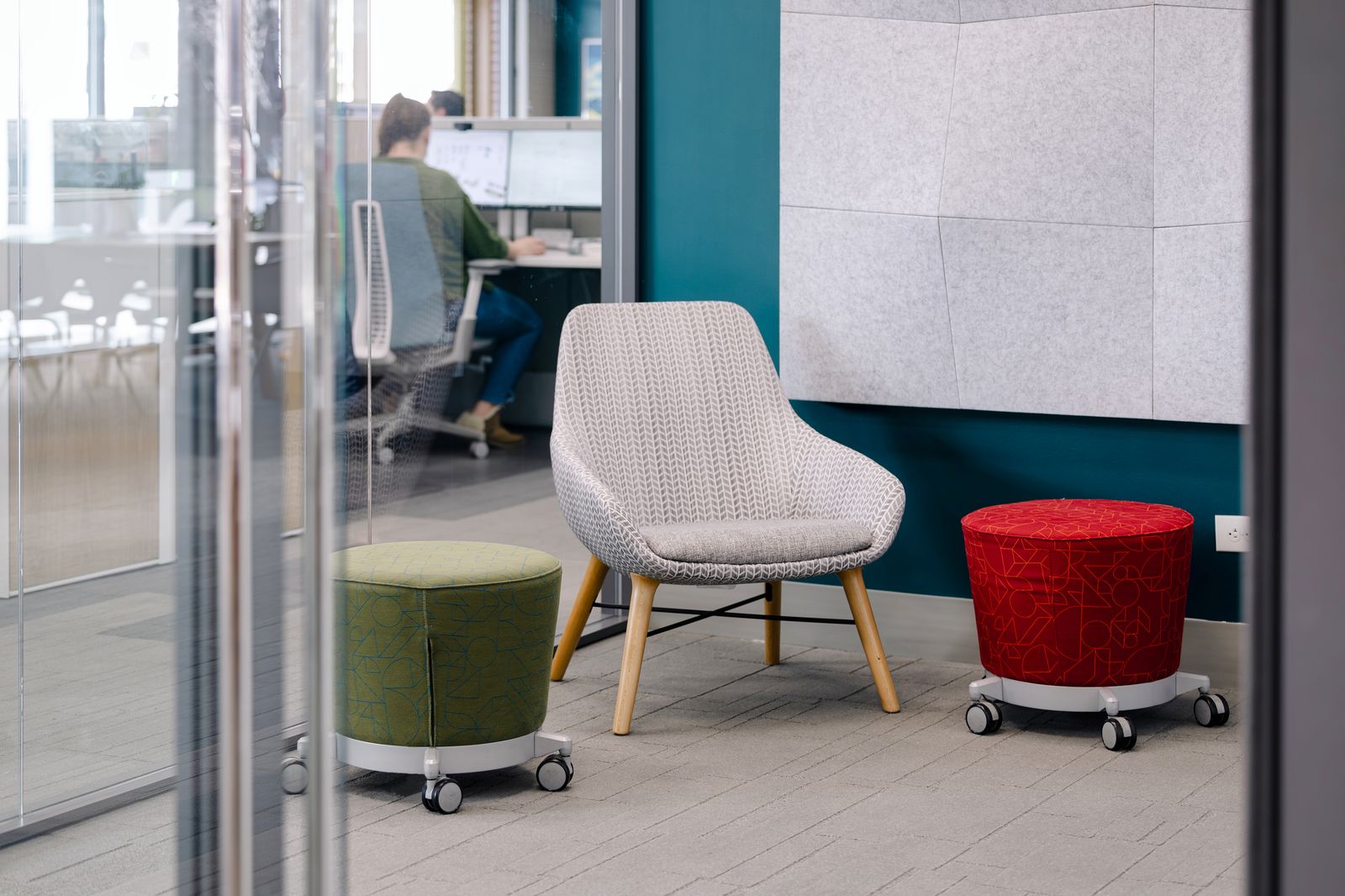 Wall acoustic panels behind a lounge chair and mobile ottomans