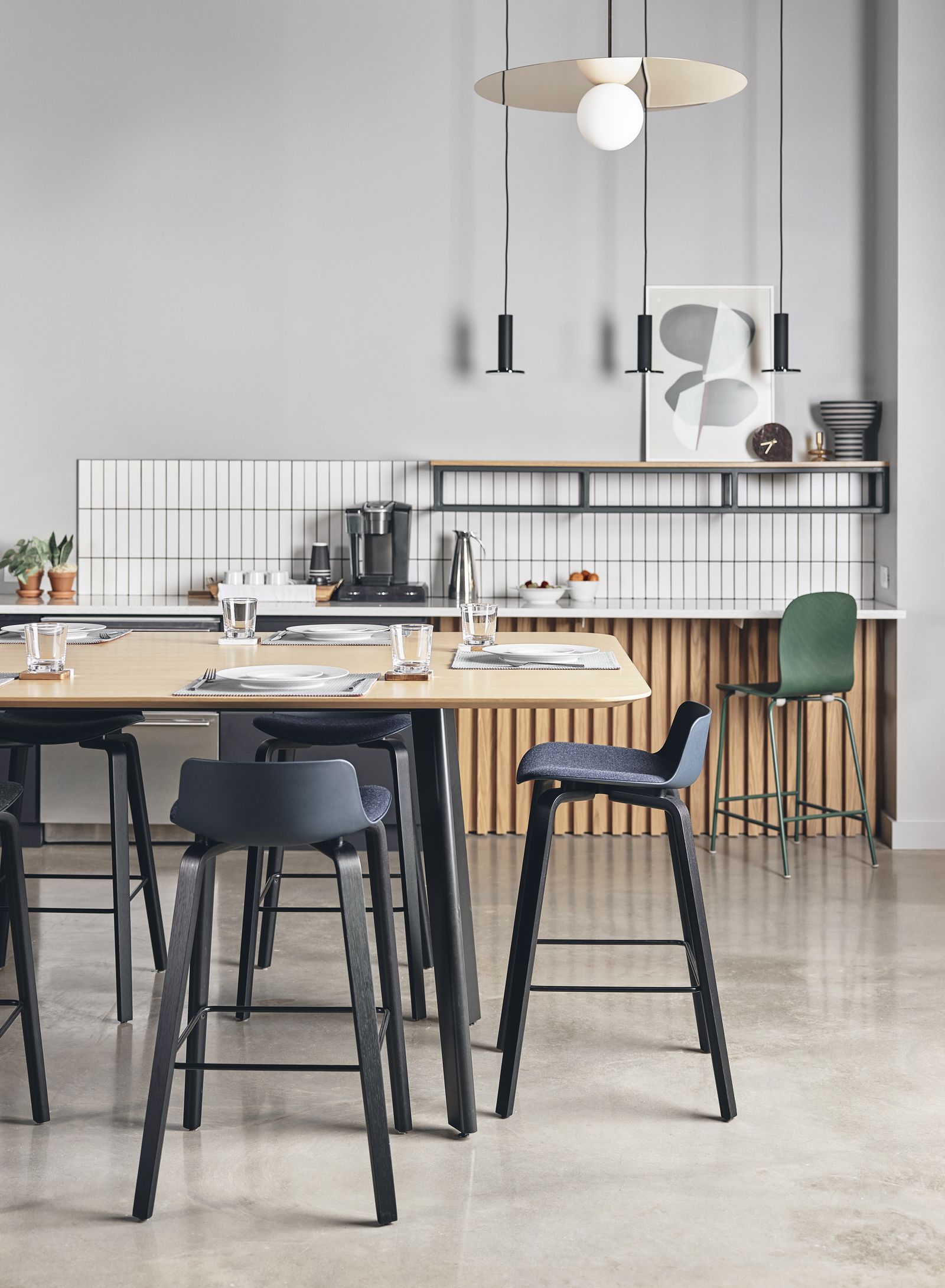 Cafe-height table with black stools under pendant lighting