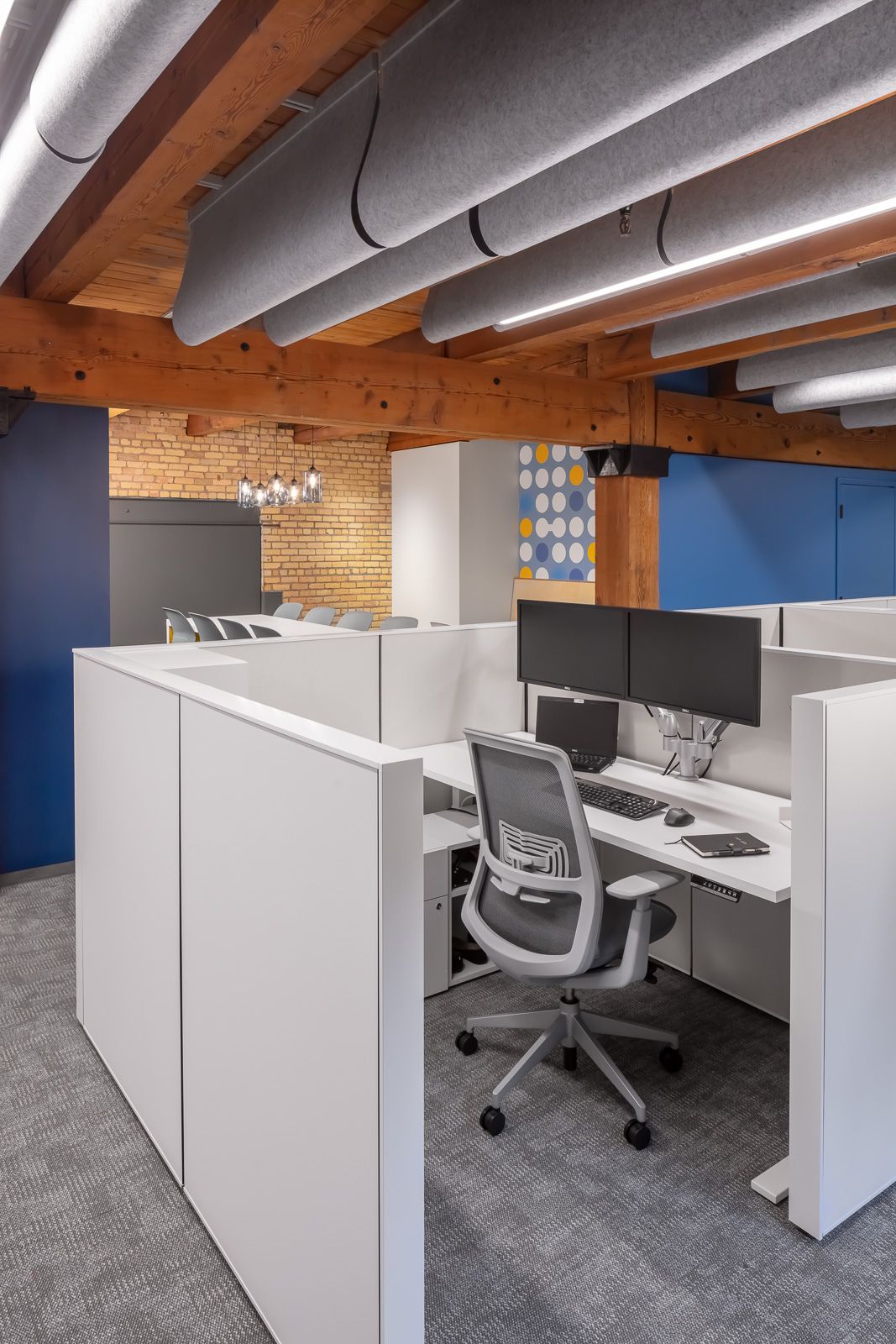 Workstation with acoustic ceiling baffles in a timber-framed office