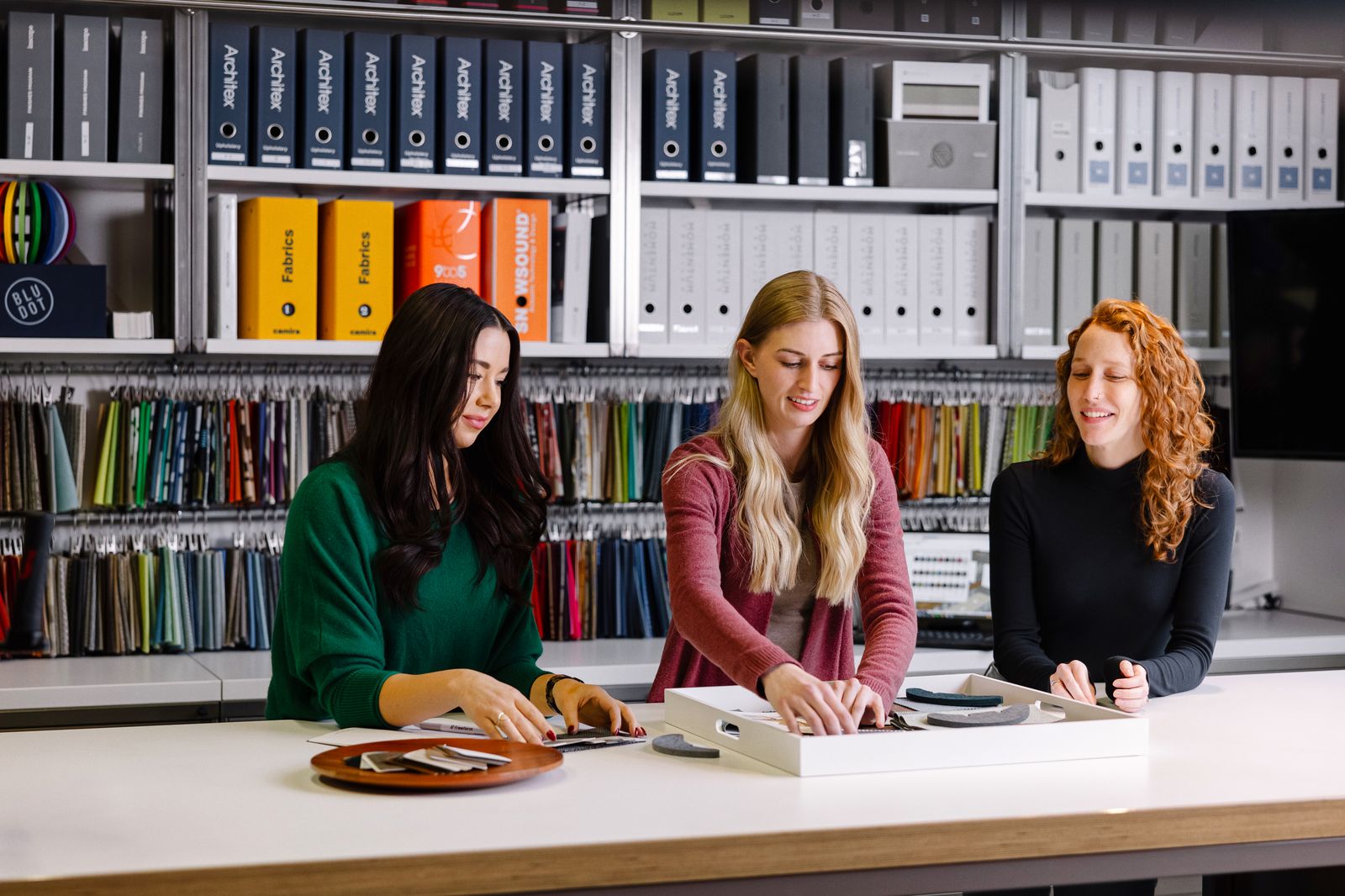 Three designers reviewing samples in front of the materials library
