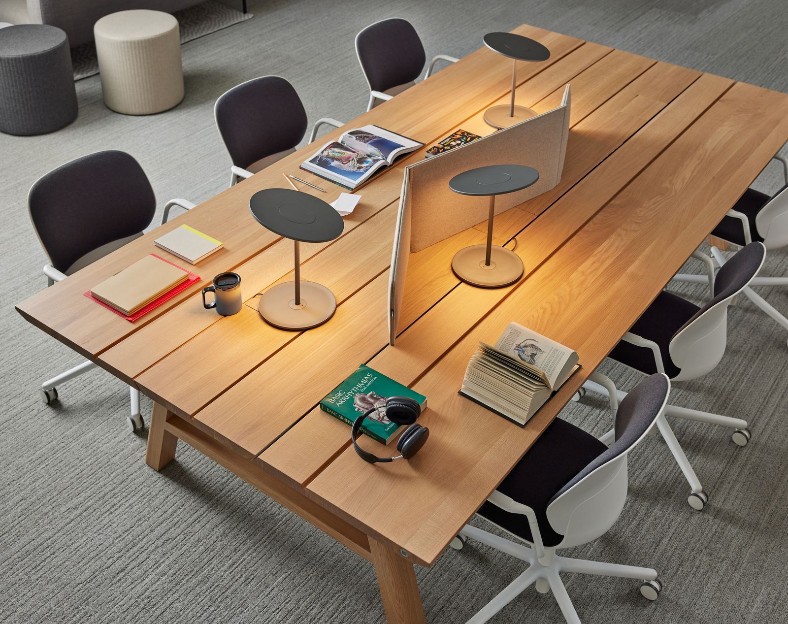 Students at a shared oak worktable with task lighting