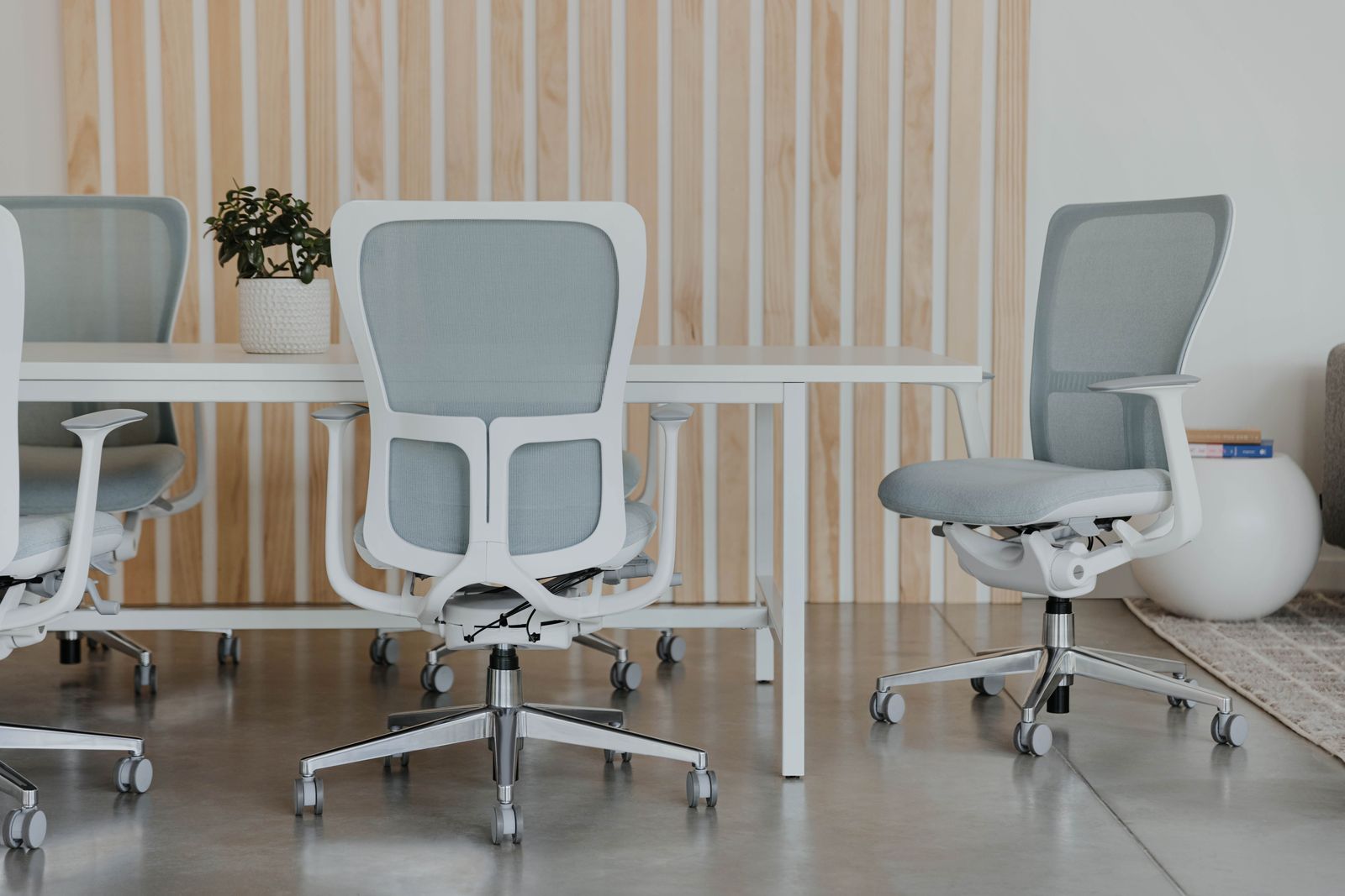 Gray task chairs at a shared desk against slatted wood