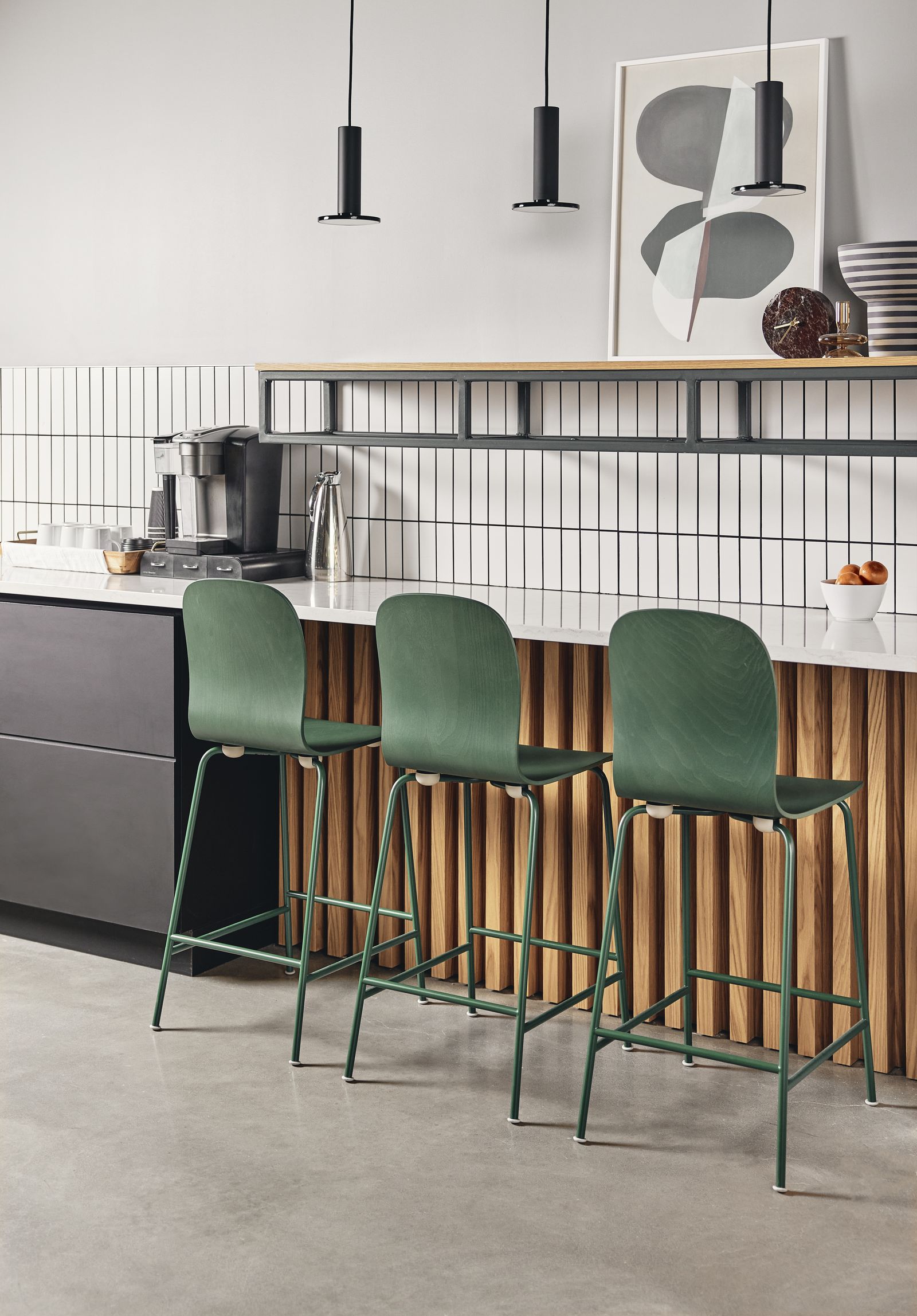 Green bar stools lined along a wood-clad counter