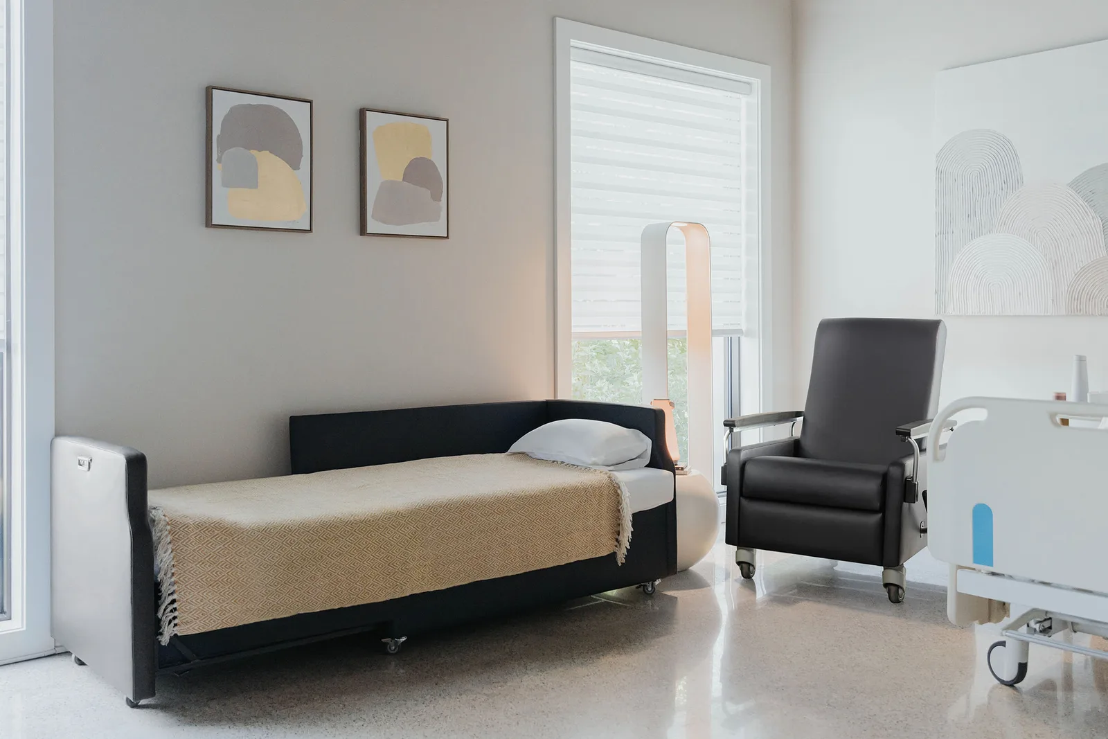 Haworth Benson patient recliner with dual transfer arms beside a hospital bed and sleep sofa in a patient room
