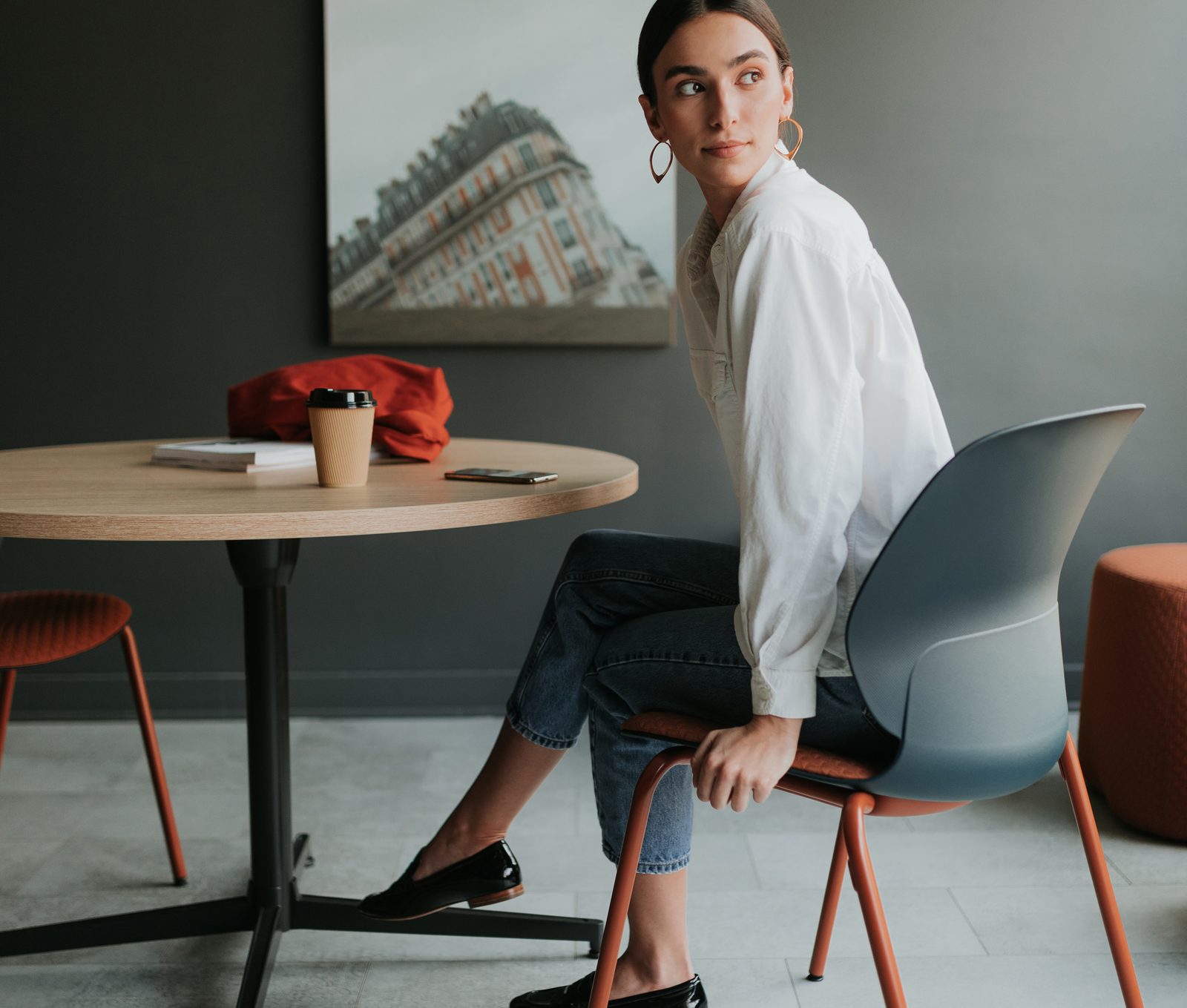 A guest seated on a Haworth Maari side chair at a round cafe table