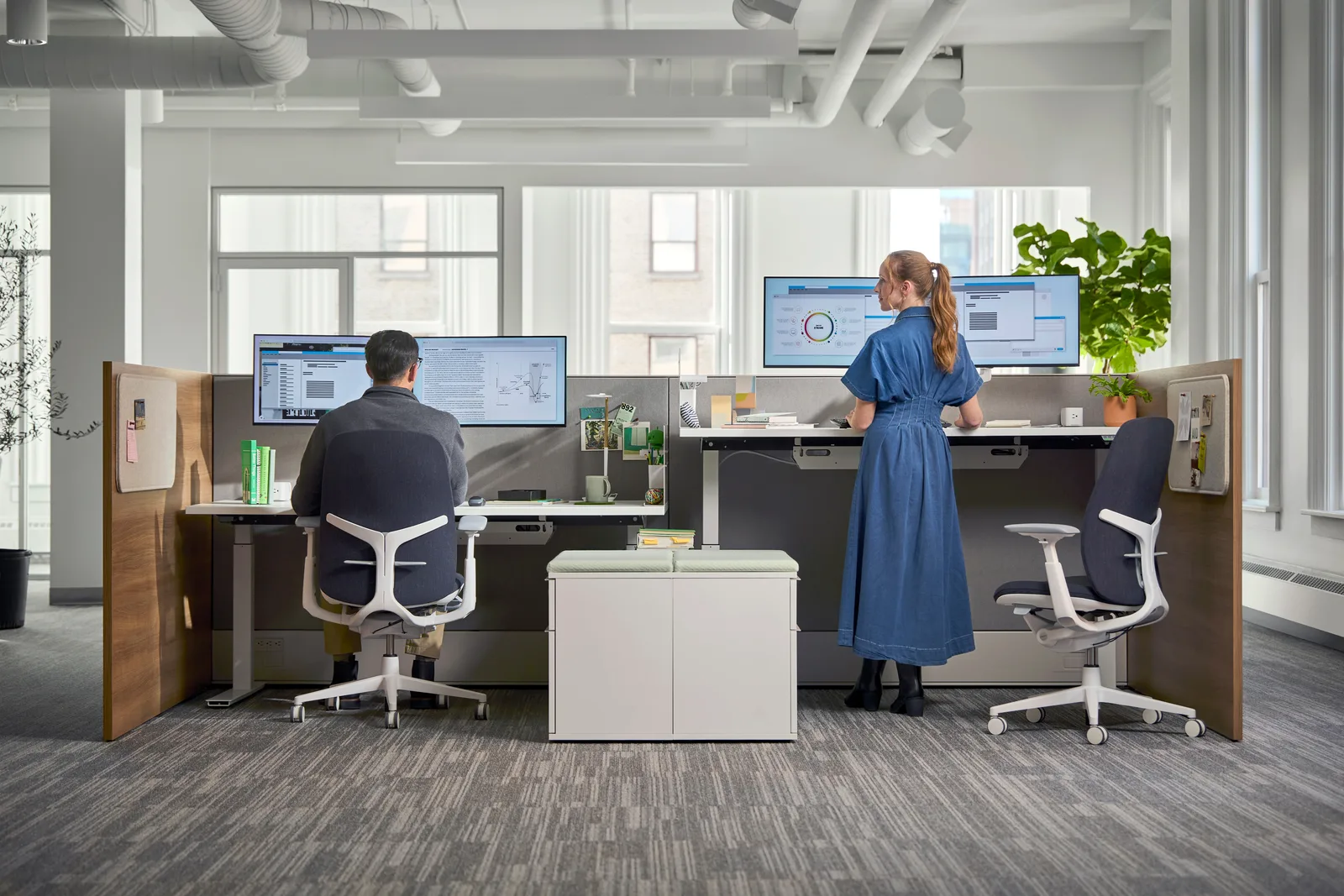 Two clinicians at Haworth Upside height-adjustable workstations with Zody LX task chairs, one seated and one standing