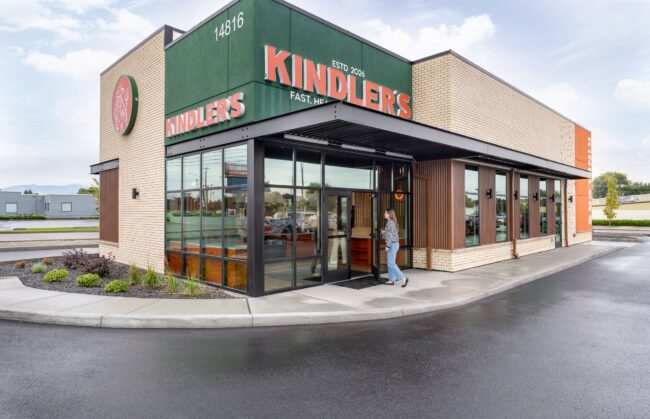 Kindler's restaurant exterior with green signage, brick facade and full-height storefront windows
