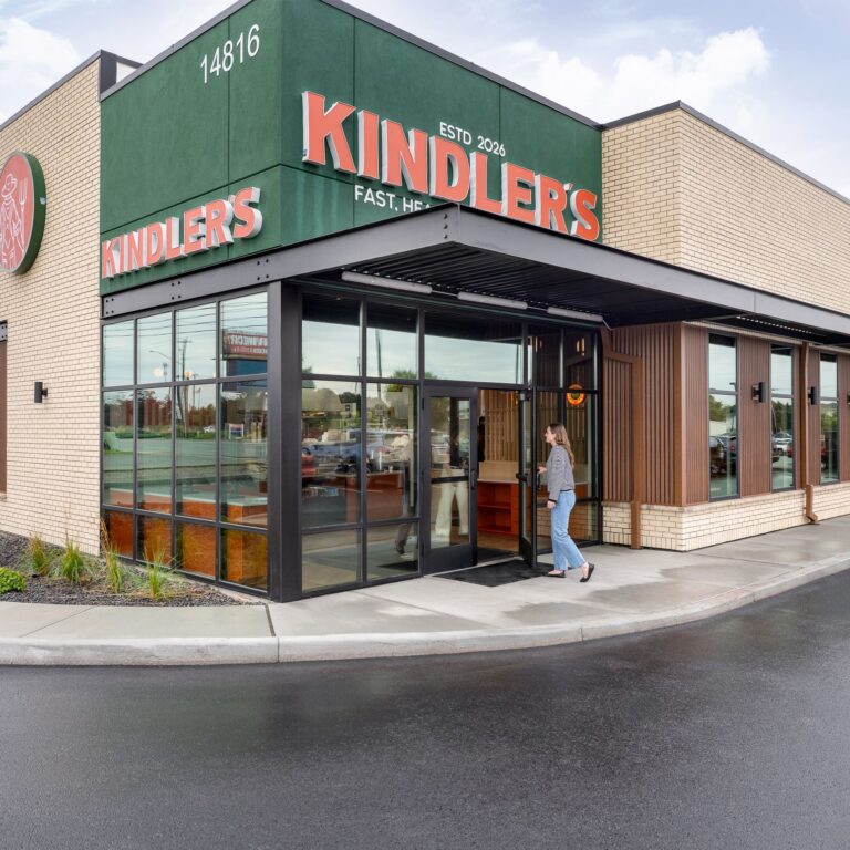 Kindler's restaurant exterior with green signage, brick facade and full-height storefront windows