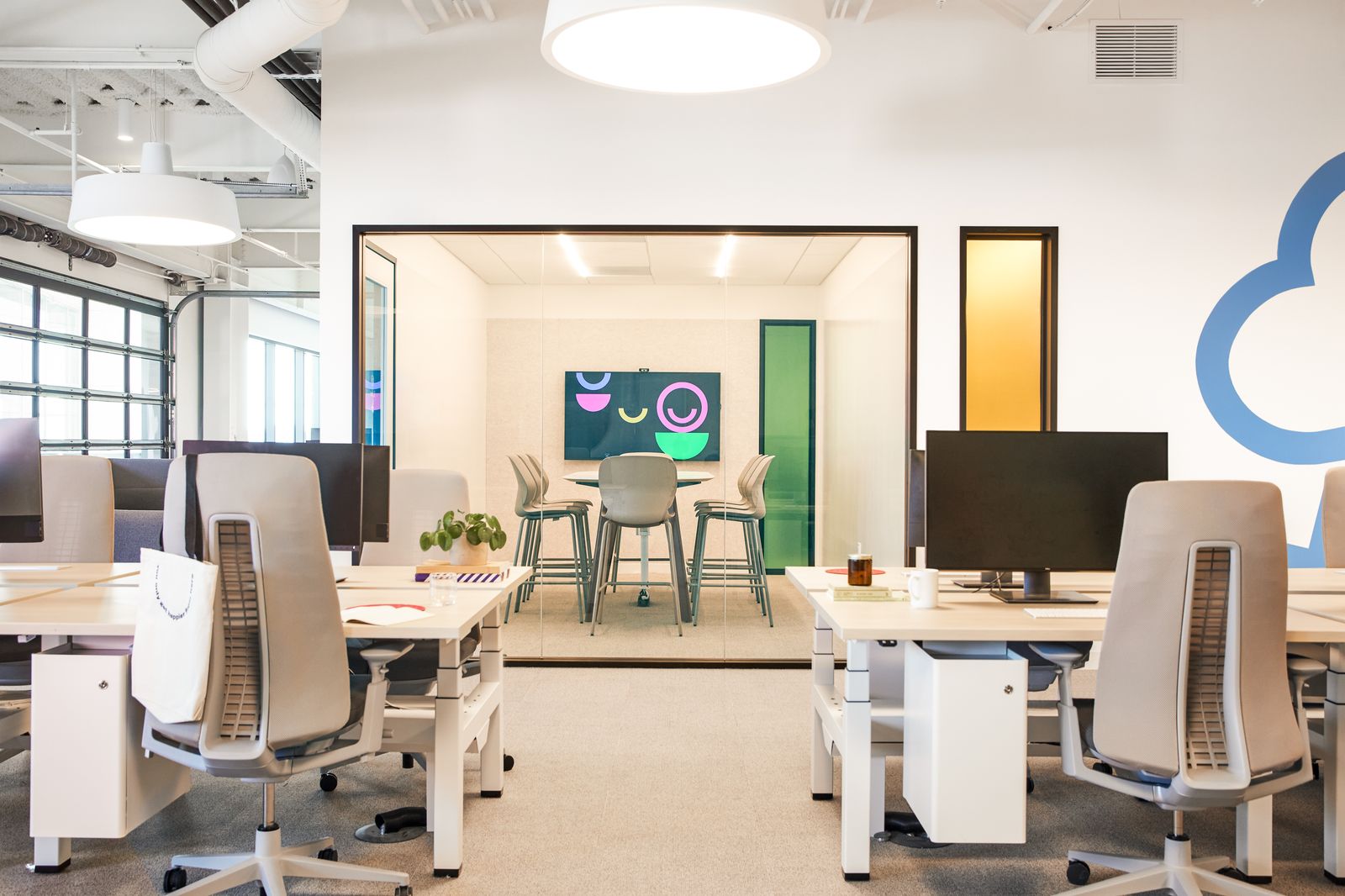 Open office with white desks and upholstered task chairs