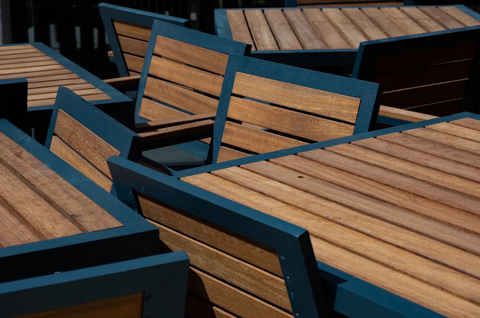Powder-coated steel outdoor tables and chairs with slatted teak surfaces