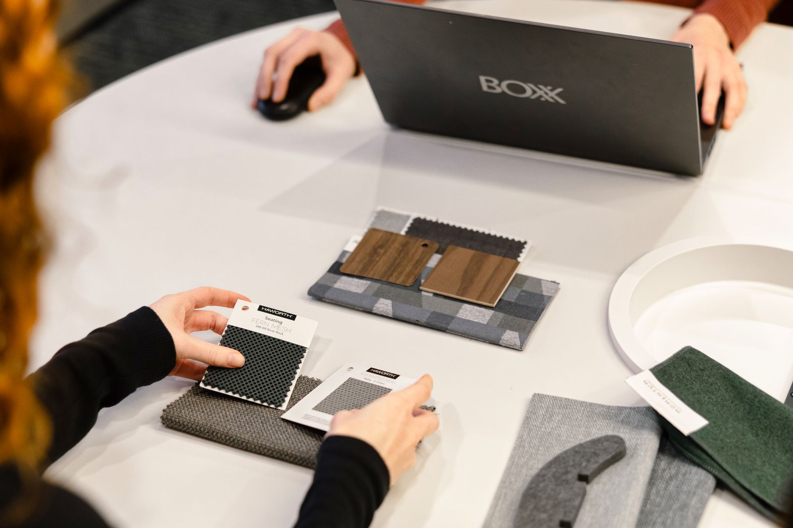 Passing material samples across the table during a design session